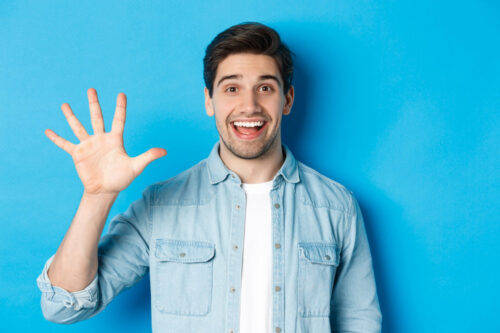close up handsome man smiling showing fingers number five standing blue background Cliente ideal, consumidores, criar persona, marketing, persona