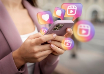 Mulher teclando no celular e ícones do instagram aparecendo na tela