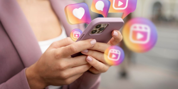 mulher teclando no celular e ícones do Instagram aparecendo na tela