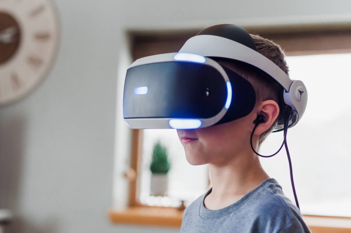 Imagem de uma criança, menino, usando um óculo de realidade virtual