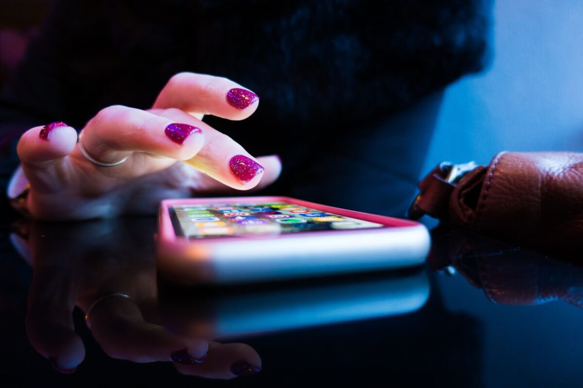 mão feminina mexendo em um celular