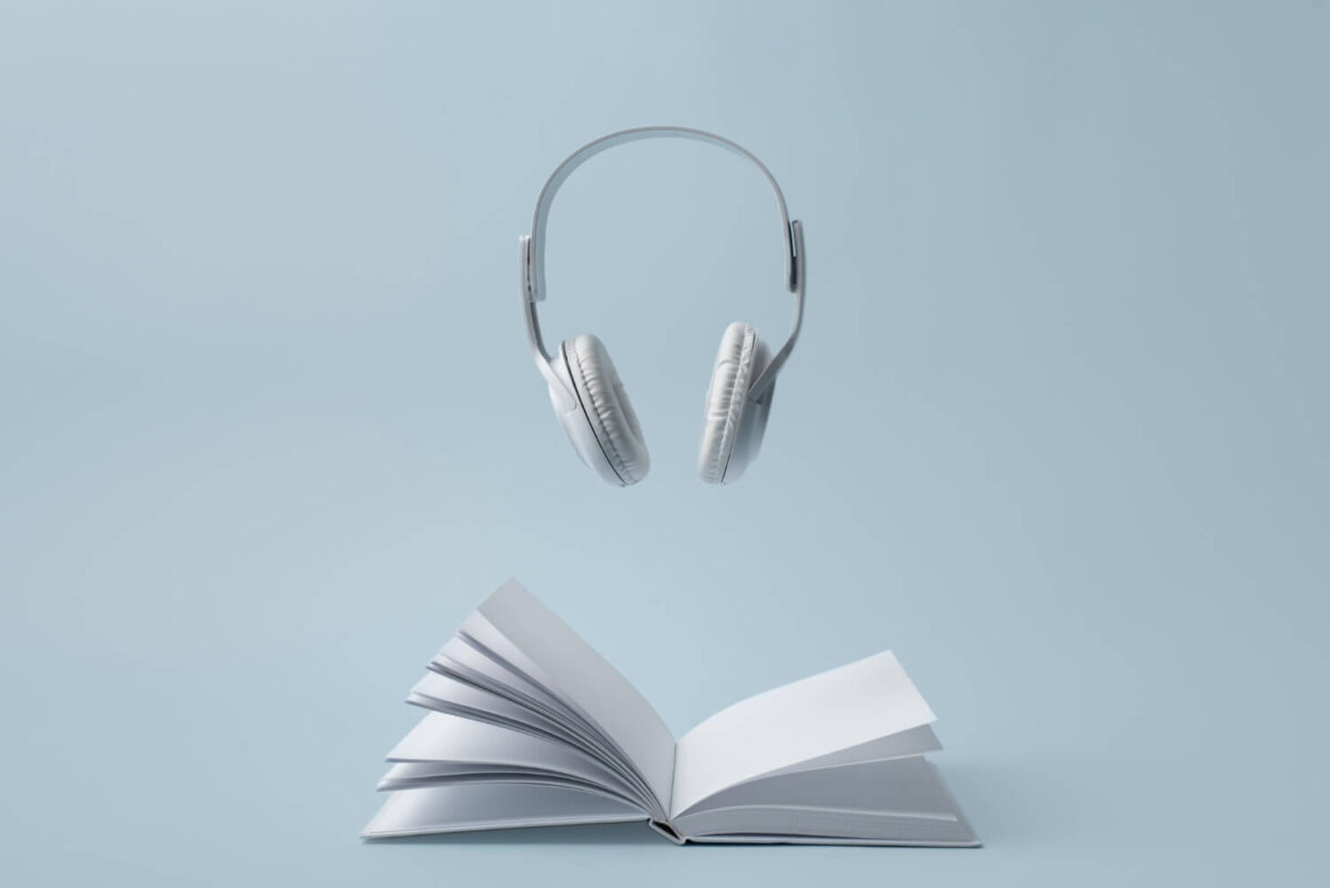 Imagem de um livro e um fone de ouvido