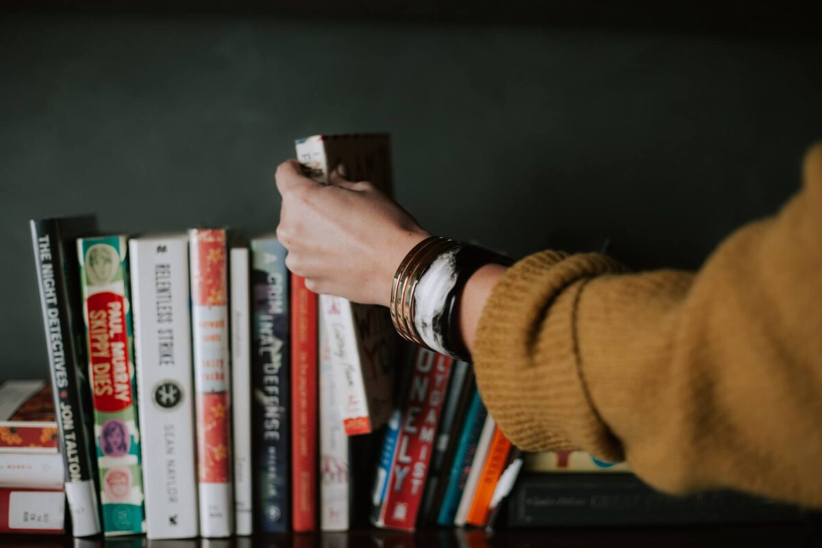 Pessoa organizando uma prateleira de livros