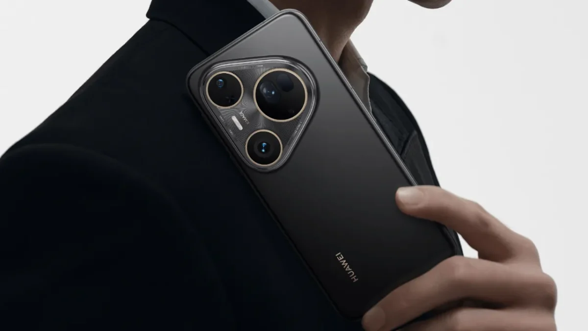 Huawei Pura 80 TecheNet A traseira de um smartphone huawei pura em preto mate, seguro por uma pessoa de fato, destacando o seu grande módulo de câmara com três lentes.