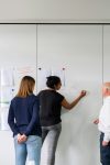 thisisengineering p5wrlynJR4A unsplash TecheNet Pessoas reunidas em uma sala de reunião enquanto uma delas escreve ideias em um quadro branco durante uma sessão de planejamento colaborativo.